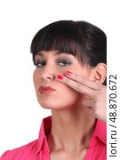 Brunette holding two finger to face. Стоковое фото, агентство Ingram Publishing / Фотобанк Лори
