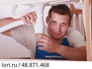Plumber repairing a siphon. Стоковое фото, агентство Ingram Publishing / Фотобанк Лори