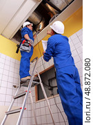 Man and woman repairing ventilation system. Стоковое фото, агентство Ingram Publishing / Фотобанк Лори