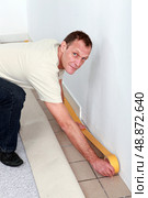 Man making preparations to fit new carpet. Стоковое фото, агентство Ingram Publishing / Фотобанк Лори
