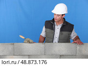 Mason stood behind wall. Стоковое фото, агентство Ingram Publishing / Фотобанк Лори