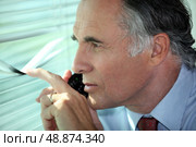 Man peering through some blinds. Стоковое фото, агентство Ingram Publishing / Фотобанк Лори