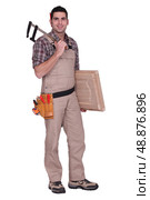 Man holding vice and cabinet door. Стоковое фото, агентство Ingram Publishing / Фотобанк Лори