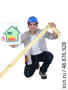 Tradesman holding a frame and an energy efficiency rating chart. Стоковое фото, агентство Ingram Publishing / Фотобанк Лори