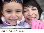 Mother and daughter giggling in the snow. Стоковое фото, агентство Ingram Publishing / Фотобанк Лори