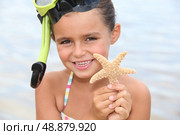 Little girl at the beach holding star fish. Стоковое фото, агентство Ingram Publishing / Фотобанк Лори