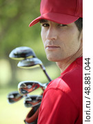 Golfer holding golf clubs. Стоковое фото, агентство Ingram Publishing / Фотобанк Лори