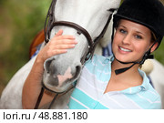Young woman caressing her horse. Стоковое фото, агентство Ingram Publishing / Фотобанк Лори