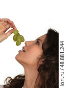 Woman eating grapes. Стоковое фото, агентство Ingram Publishing / Фотобанк Лори