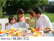 Family having brunch outside on a sunny day. Стоковое фото, агентство Ingram Publishing / Фотобанк Лори