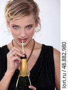 Woman drinking champagne through a straw. Стоковое фото, агентство Ingram Publishing / Фотобанк Лори