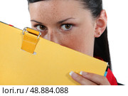 Woman hiding behind a folder. Стоковое фото, агентство Ingram Publishing / Фотобанк Лори