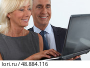 Business professionals looking at a laptop. Стоковое фото, агентство Ingram Publishing / Фотобанк Лори