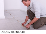 Man taping down underlay. Стоковое фото, агентство Ingram Publishing / Фотобанк Лори