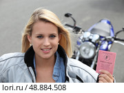 Teenage girl with motorbike and driving licence. Стоковое фото, агентство Ingram Publishing / Фотобанк Лори