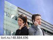 Young business couple using their mobile telephones. Стоковое фото, агентство Ingram Publishing / Фотобанк Лори