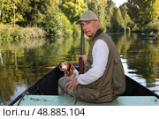 Hunter with a shotgun and dog on a boat. Стоковое фото, агентство Ingram Publishing / Фотобанк Лори