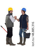 Two construction workers greeting each other. Стоковое фото, агентство Ingram Publishing / Фотобанк Лори
