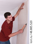 man wallpapering. Стоковое фото, агентство Ingram Publishing / Фотобанк Лори