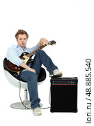 Boy in armchair with guitar and amp. Стоковое фото, агентство Ingram Publishing / Фотобанк Лори