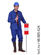 Construction worker standing with a mallet and traffic sign. Стоковое фото, агентство Ingram Publishing / Фотобанк Лори
