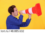 young blue collar shouting in construction cone. Стоковое фото, агентство Ingram Publishing / Фотобанк Лори