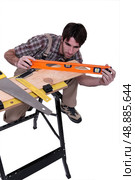 Carpenter leveling plank. Стоковое фото, агентство Ingram Publishing / Фотобанк Лори