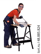 Young woman cutting a tile. Стоковое фото, агентство Ingram Publishing / Фотобанк Лори