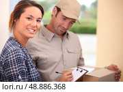 Woman signing for a package. Стоковое фото, агентство Ingram Publishing / Фотобанк Лори