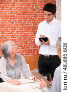 Young waiter taking an order in a restaurant. Стоковое фото, агентство Ingram Publishing / Фотобанк Лори