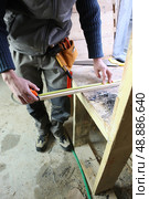 Carpenter measuring plank of wood. Стоковое фото, агентство Ingram Publishing / Фотобанк Лори