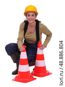 Woman kneeling by traffic cones. Стоковое фото, агентство Ingram Publishing / Фотобанк Лори