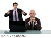Man rejoicing behind colleague. Стоковое фото, агентство Ingram Publishing / Фотобанк Лори