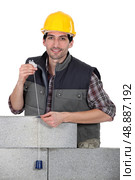 mason making measurements with a cord. Стоковое фото, агентство Ingram Publishing / Фотобанк Лори