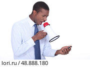 Man shouting through a megaphone at a cellphone. Стоковое фото, агентство Ingram Publishing / Фотобанк Лори