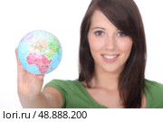 young woman holding out world globe. Стоковое фото, агентство Ingram Publishing / Фотобанк Лори