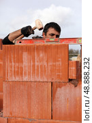 Mason adjusting brick wall. Стоковое фото, агентство Ingram Publishing / Фотобанк Лори