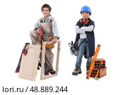 Two children acting out adult trades - carpentry and construction. Стоковое фото, агентство Ingram Publishing / Фотобанк Лори