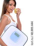 woman holding apple and bathroom scales. Стоковое фото, агентство Ingram Publishing / Фотобанк Лори