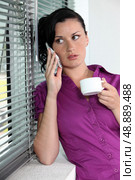 Woman with telephone and coffee cup. Стоковое фото, агентство Ingram Publishing / Фотобанк Лори