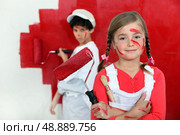Children painting a wall red. Стоковое фото, агентство Ingram Publishing / Фотобанк Лори