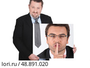 moon-faced man wearing coat and tie showing picture of young man with finger in mouth. Стоковое фото, агентство Ingram Publishing / Фотобанк Лори