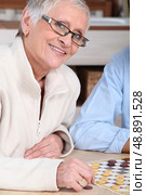 portrait of an old woman playing checkers. Стоковое фото, агентство Ingram Publishing / Фотобанк Лори