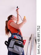 Woman measuring a wire’s electrical current. Стоковое фото, агентство Ingram Publishing / Фотобанк Лори