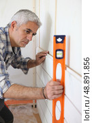 Man using a spirit level. Стоковое фото, агентство Ingram Publishing / Фотобанк Лори