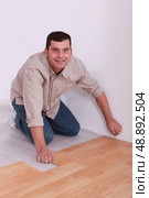 35 years old handyman laying parquet. Стоковое фото, агентство Ingram Publishing / Фотобанк Лори