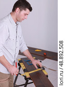Man measuring plank of wood. Стоковое фото, агентство Ingram Publishing / Фотобанк Лори
