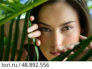 Woman hiding behind leaves. Стоковое фото, агентство Ingram Publishing / Фотобанк Лори