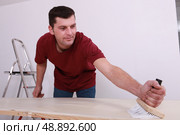 Man gluing paper. Стоковое фото, агентство Ingram Publishing / Фотобанк Лори