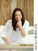 Brunette say on sofa. Стоковое фото, агентство Ingram Publishing / Фотобанк Лори